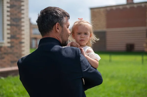 Любящий отец держит за руки свою маленькую дочь на улице. — стоковое фото