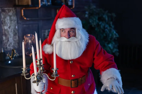 Santa Claus se acerca por la noche y sostiene un candelabro. — Foto de Stock