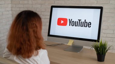16 Eylül 2020 Rusya, Novosibirsk: Ekranda YouTube logosu olan bir kadının bilgisayar başında oturması.