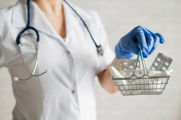 Uma médica feminina sem rosto segura uma mini cesta com medicamentos — Fotografia de Stock