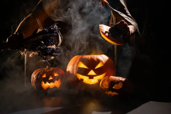 Čarodějnice seslala kouzlo na kouřící dýni ve tmě na Halloween — Stock fotografie