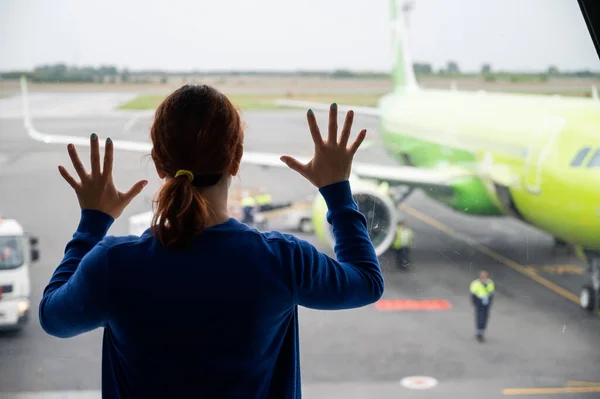 La mujer se inclinó hacia la ventana del aeropuerto — Foto de Stock