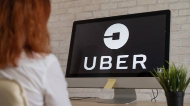 10 Eylül 2020 Rusya, Novosibirsk: Uber logosu olan bir kadın bilgisayarın başında oturuyor