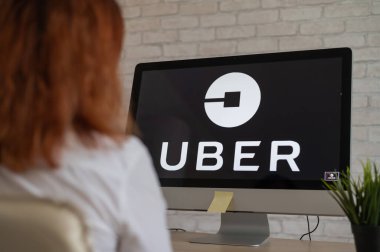 10 Eylül 2020 Rusya, Novosibirsk: Uber logosu olan bir kadın bilgisayarın başında oturuyor