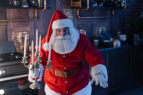 Nachts schleicht der Weihnachtsmann herbei und hält einen Kerzenständer. — Stockfoto