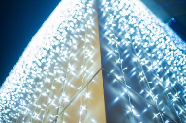 Noel arkaplanı - Bokeh efektli mavi ve beyaz çelenk ışıklarını kapat