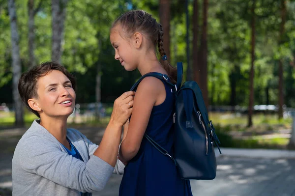 Белая женщина собирает свою первоклассницу дочь в школу — стоковое фото