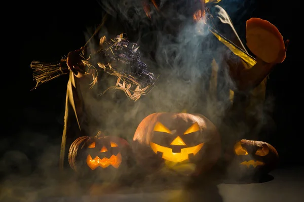 Czarownica rzuca zaklęcie na parującą dynię w ciemności w Halloween — Zdjęcie stockowe
