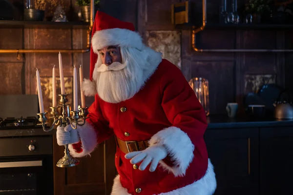 Santa Claus se acerca por la noche y sostiene un candelabro. — Foto de Stock