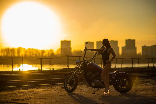 Femme aux cheveux rouges en lingerie sexy en talons hauts s'assoit sur une moto — Photo