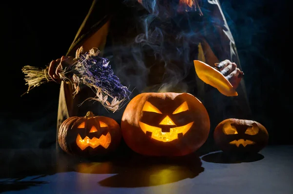 Czarownica rzuca zaklęcie na parującą dynię w ciemności w Halloween — Zdjęcie stockowe