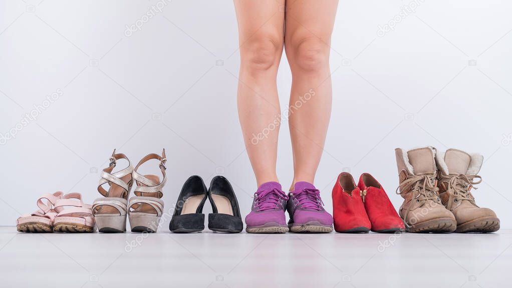 The woman prefers sneakers. Collection of womens shoes in a row on a white background