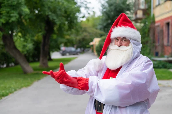 Santa Claus en traje protector se pone guantes. —  Fotos de Stock