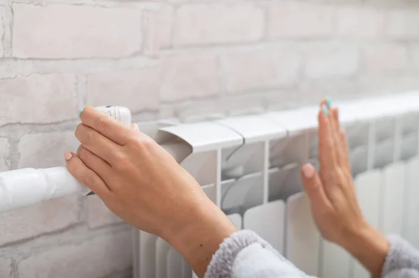 Close-up de uma mão feminina que regula a temperatura de um radiador de aquecimento — Fotografia de Stock