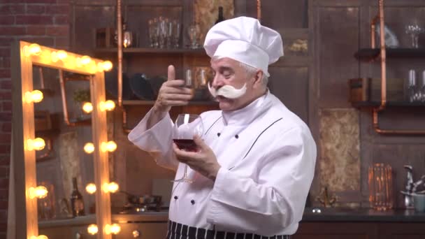 Un vieux chef dégustation de vin rouge dans la cuisine — Video