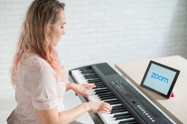 Május 25, 2020 Novoszibirszk Oroszország: kaukázusi nő távolról tanul zongorázni a ZOOM app egy digitális táblagépen — Stock Fotó