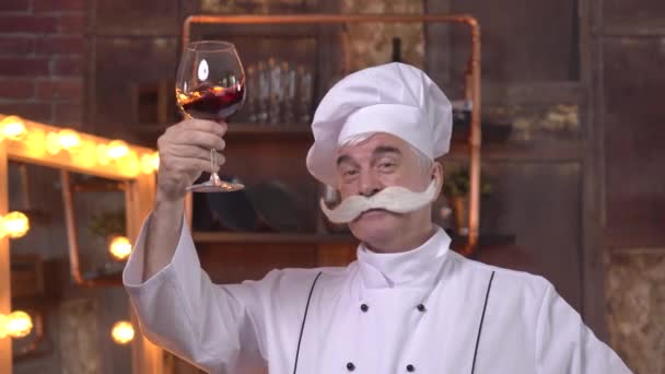 Un vieux chef dégustation de vin rouge dans la cuisine — Video