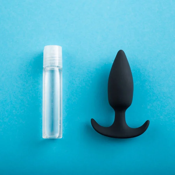 Top view of black anal plug and tube of lubricant on a blue background — Stock Photo, Image