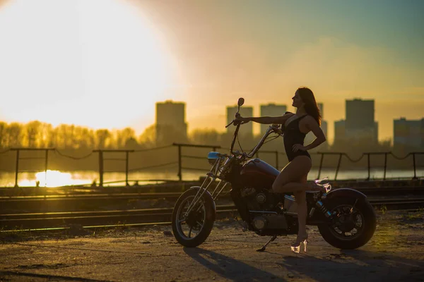 Red-haired woman in sexy lingerie in high heels sits on a motorcycle — Stock Photo, Image