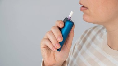 Elektronik sigara içen beyaz bir kadın. Tütün ısıtma sistemi