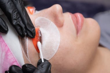 Beyaz kadın kirpik temizleme prosedüründen geçiyor.