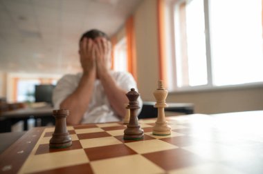 Orta yaşlı beyaz adam satranç oynuyor.