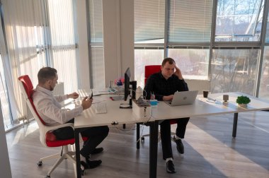 Bir ofiste çalışan iki beyaz adam.