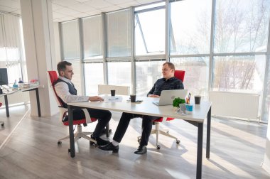 Bir ofiste pazarlık yapan iki beyaz adam.