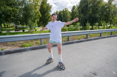 Beyaz şortlu kadın paten kayıyor.
