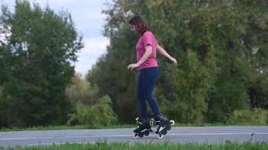 Beyaz kadın parkta paten kayıyor.