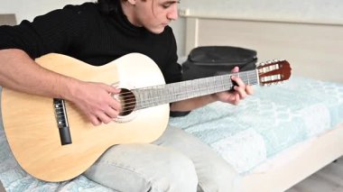 Genç adam akustik gitar çalıyor. Parmak Biçimi