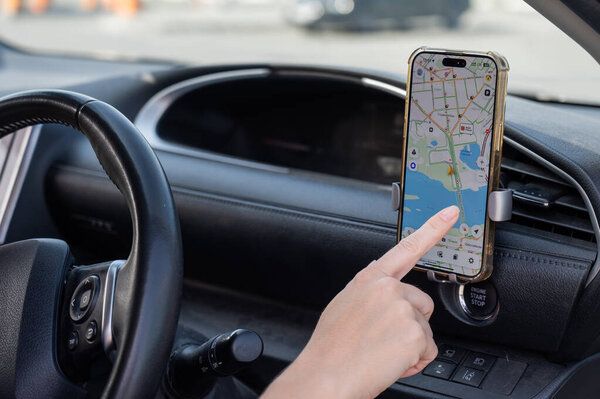 08.09.2025 Russia, Novosibirsk: A woman uses Yandex maps on her phone while driving a car
