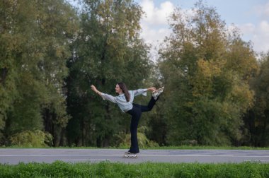 Beyaz kadın parkta paten kayıyor.