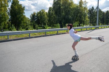 Beyaz şortlu kadın paten kayıyor.