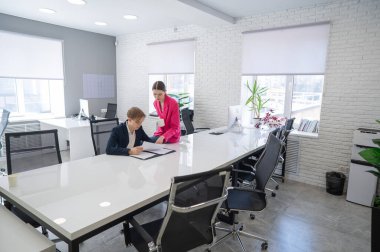 Beyaz kadın astlarına talimat veriyor.