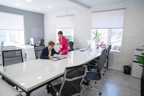 Beyaz kadın astlarına talimat veriyor.