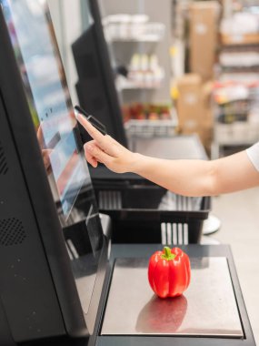 Bir kadın kasadan dolmalık biber alıyor.