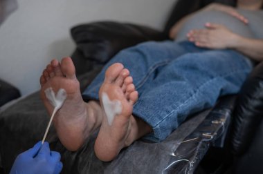 Güzellik salonunda hırdavat pedikür yapan hamile bir kadın.