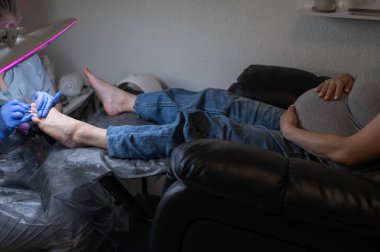 Güzellik salonunda hırdavat pedikür yapan hamile bir kadın.