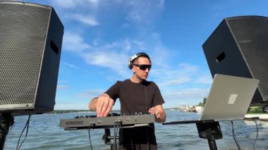 Beyaz adam plajda DJ olarak çalışıyor.