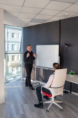 Beyaz bir kurulda iş tartışan iki beyaz adam.