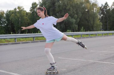 Beyaz şortlu kadın paten kayıyor.