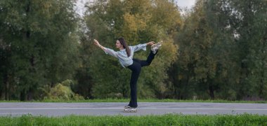 Beyaz kadın parkta paten kayıyor.