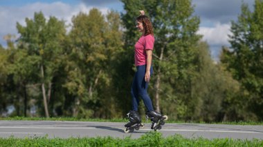 Beyaz kadın parkta paten kayıyor.