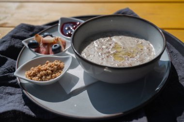 Bir kafede kahvaltı rezervasyonu. Bir sokak kafesindeki masada bir tabak yulaf lapası.
