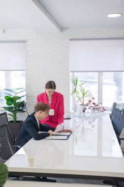 Beyaz kadın astlarına talimat veriyor.