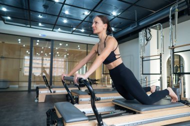 Kafkas kadın yenilikçi makineler üzerinde egzersiz yapıyor.