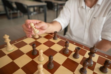 Orta yaşlı beyaz bir adamın satranç oynaması yakındır.