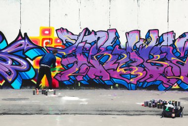Moskova, Rusya - Eylül 7, 2009: Genç adam renkli beton duvar grafiti boyalar