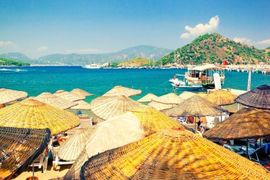 Türk Rivierası'nın güneşli plajında pitoresk hasır plaj şemsiyeleri. İçmeler, Muğla İli